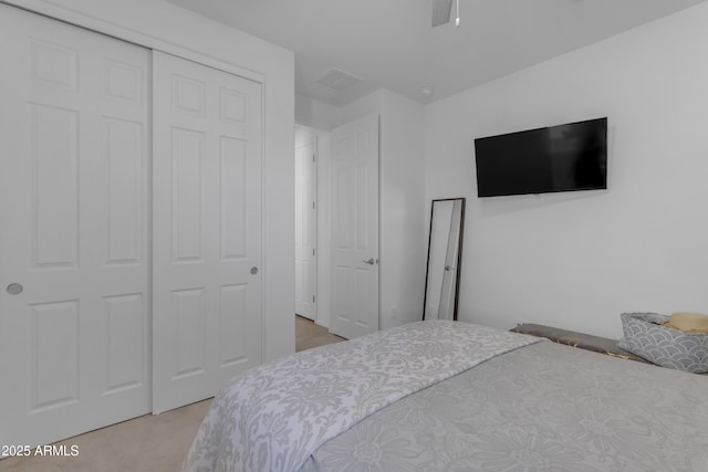 bedroom featuring light colored carpet and a closet