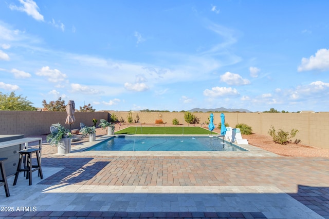 view of swimming pool featuring pool water feature and a patio area