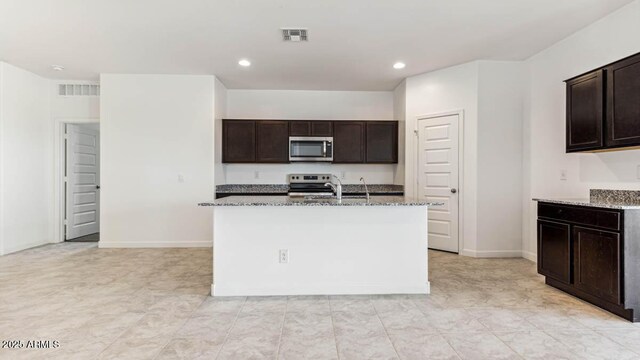 kitchen featuring appliances with stainless steel finishes, an island with sink, and visible vents