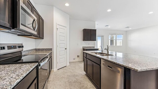 kitchen featuring a kitchen island with sink, recessed lighting, stainless steel appliances, a sink, and dark brown cabinets