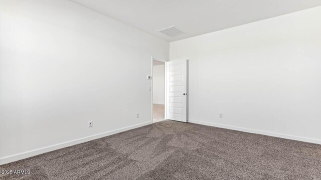 spare room with carpet, visible vents, and baseboards