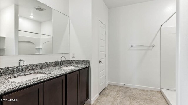 full bathroom with a sink, baseboards, and double vanity