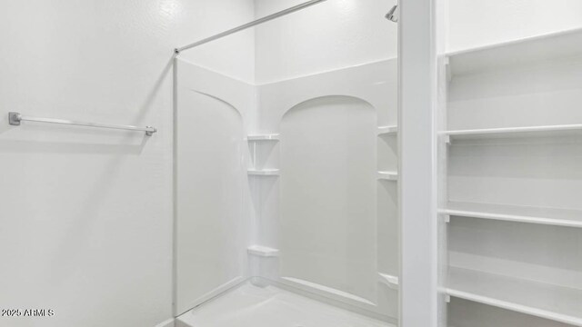 full bathroom with a stall shower and a closet