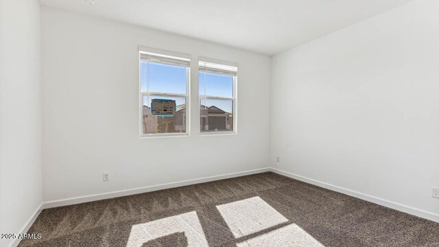 carpeted empty room featuring baseboards