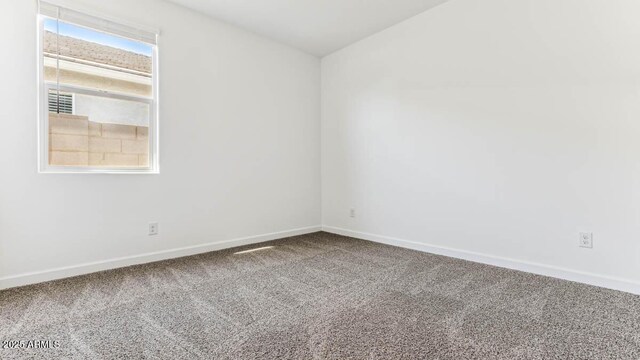 carpeted spare room featuring baseboards