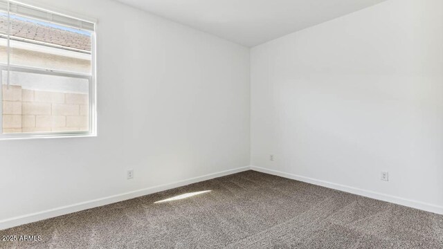 carpeted spare room with baseboards