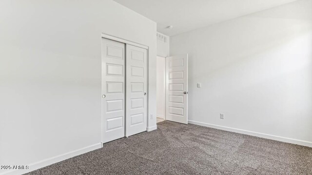 unfurnished bedroom with carpet, a closet, visible vents, and baseboards