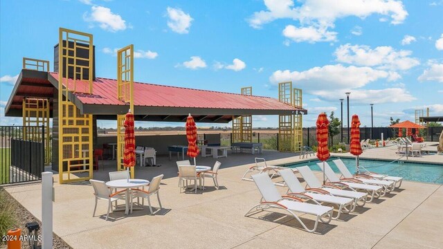 pool with a patio area and fence