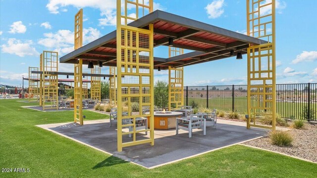 view of play area with a patio area, an outdoor fire pit, fence, and a yard