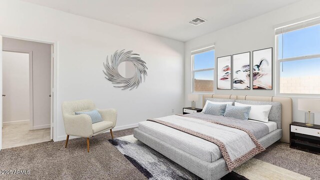 bedroom with light carpet, visible vents, and baseboards