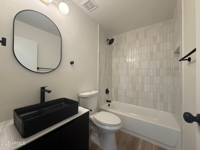 full bathroom with wood finished floors, toilet, vanity, and shower / bathtub combination