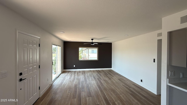 foyer entrance featuring dark wood finished floors, a ceiling fan, baseboards, and a textured ceiling