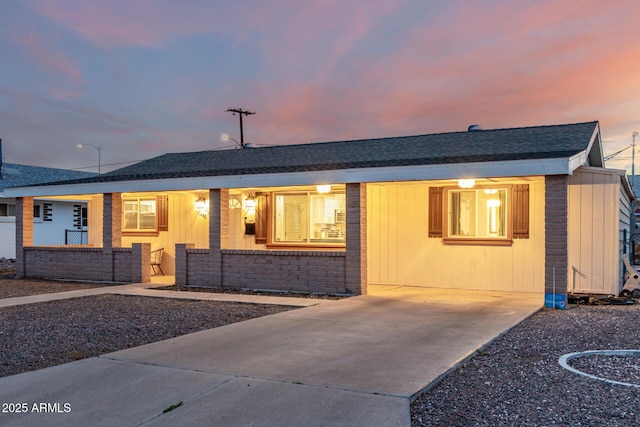 single story home featuring brick siding and roof with shingles