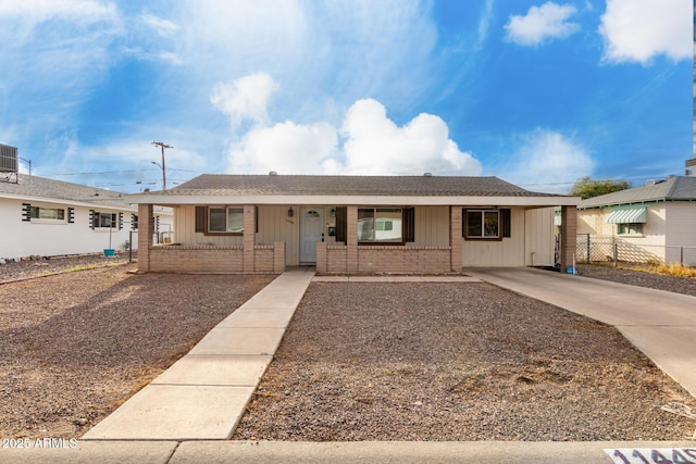 single story home with board and batten siding, brick siding, covered porch, and fence