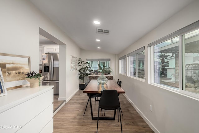 dining room featuring visible vents, wood finished floors, recessed lighting, baseboards, and lofted ceiling