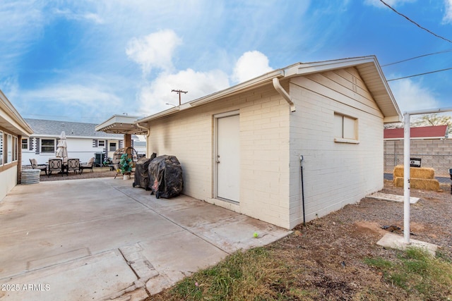 view of side of home featuring a patio and fence