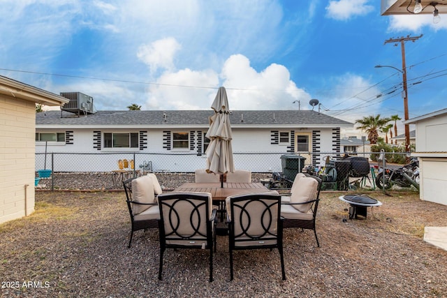 back of house featuring cooling unit, fence, roof with shingles, and an outdoor fire pit