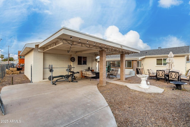 back of property with brick siding, a patio, and fence