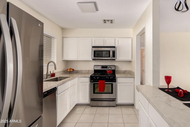 2130 W Colter St, Phoenix, AZ 85015 - kitchen featuring appliances with stainless steel finishes, a sink, light tile patterned floors, and white cabinetry