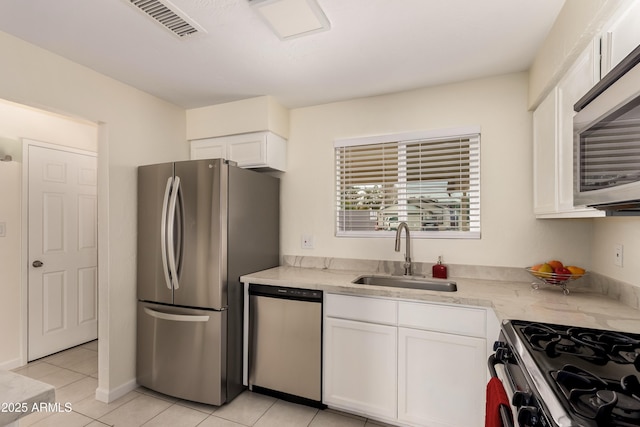 2130 W Colter St, Phoenix, AZ 85015 - kitchen featuring appliances with stainless steel finishes, a sink, white cabinetry, and light tile patterned flooring