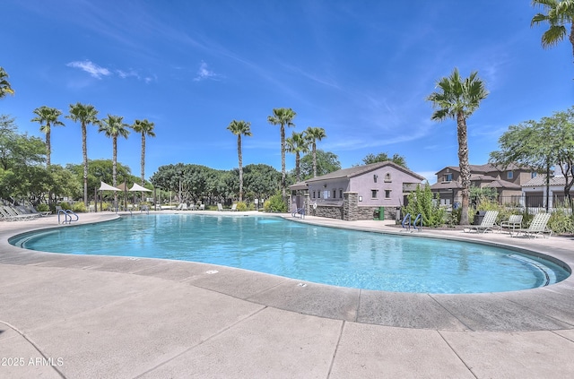 pool with a patio area, a residential view, and fence