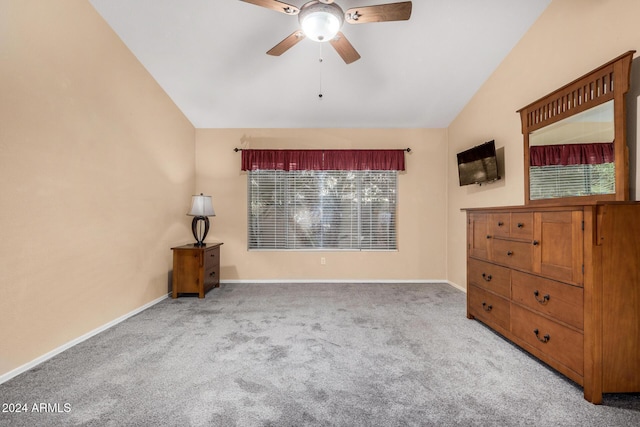 unfurnished bedroom featuring carpet flooring, multiple windows, ceiling fan, and lofted ceiling