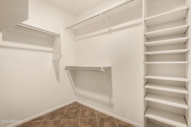 spacious closet featuring dark tile patterned floors