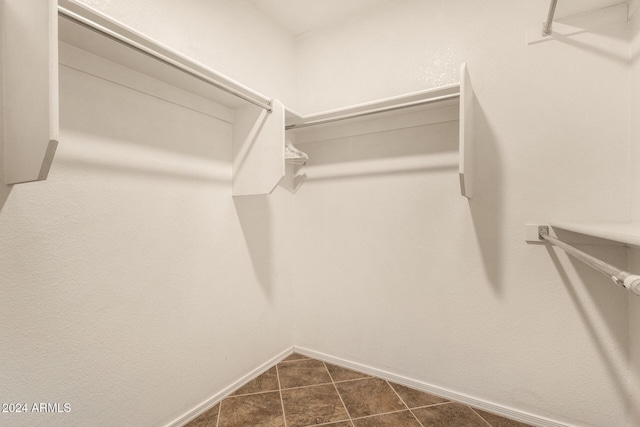 walk in closet featuring dark tile patterned floors