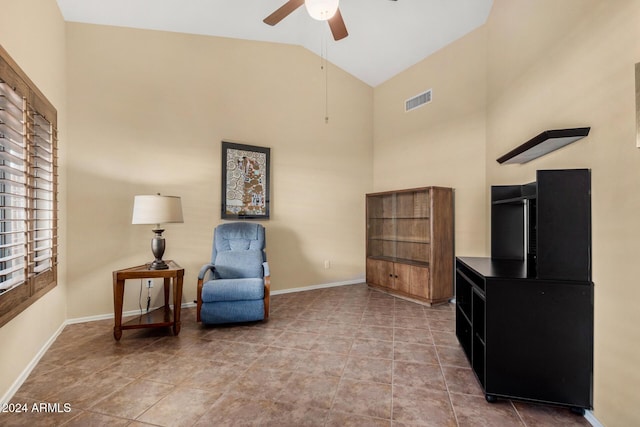 sitting room with tile patterned floors, ceiling fan, and high vaulted ceiling