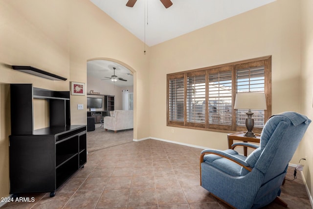 living area featuring tile patterned floors, high vaulted ceiling, and ceiling fan