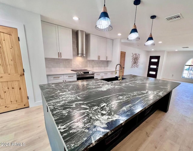 kitchen featuring white cabinetry, sink, stainless steel electric range, and a center island with sink