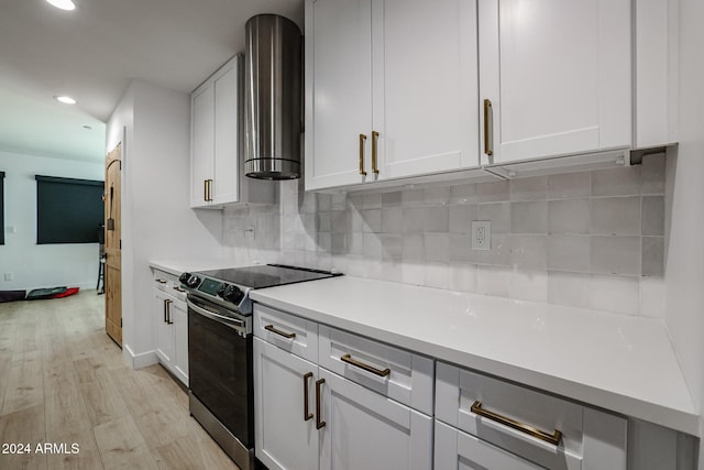 kitchen with backsplash, stainless steel electric range oven, and white cabinetry