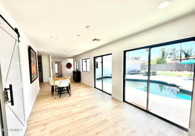 interior space featuring a barn door and light hardwood / wood-style flooring