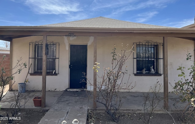 view of exterior entry featuring stucco siding