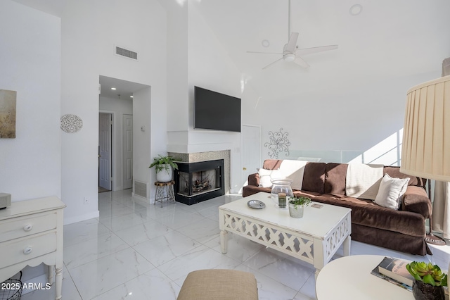 living room featuring ceiling fan and a towering ceiling