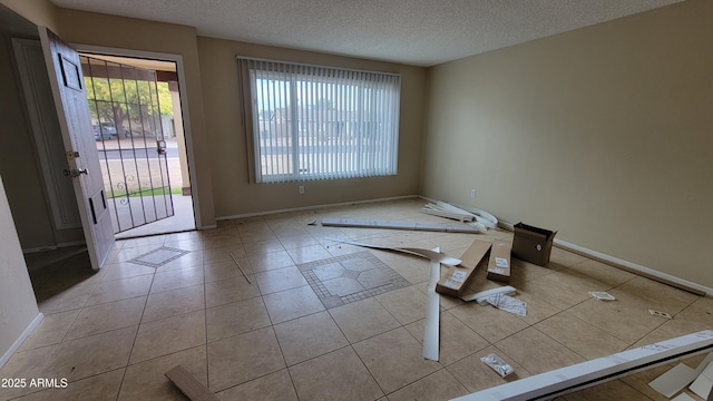 spare room featuring light tile patterned flooring and a textured ceiling