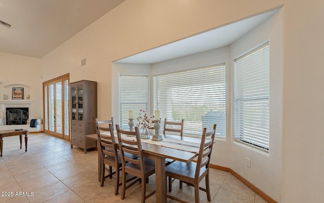 26215 N 115th Ave, Peoria, AZ 85383 - dining area featuring light tile patterned floors, a fireplace with raised hearth, and baseboards