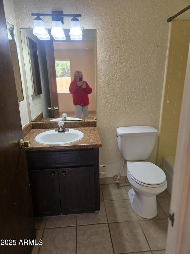 bathroom with toilet, walk in shower, a textured wall, and tile patterned flooring