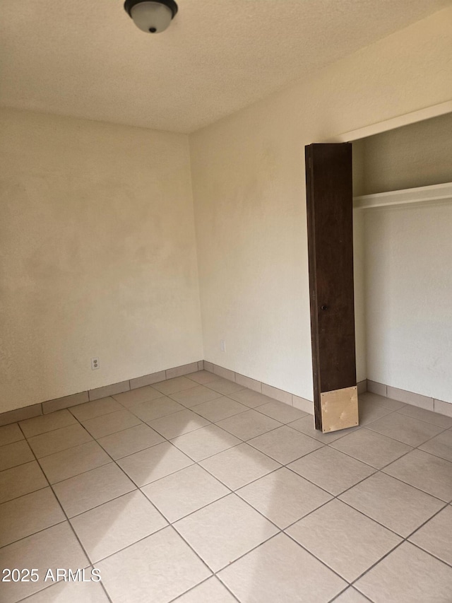 unfurnished bedroom with a closet and light tile patterned floors