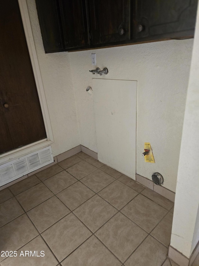 laundry room featuring cabinet space, visible vents, and light tile patterned floors