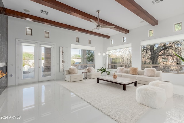 living room with tile patterned flooring, french doors, ceiling fan, and beamed ceiling