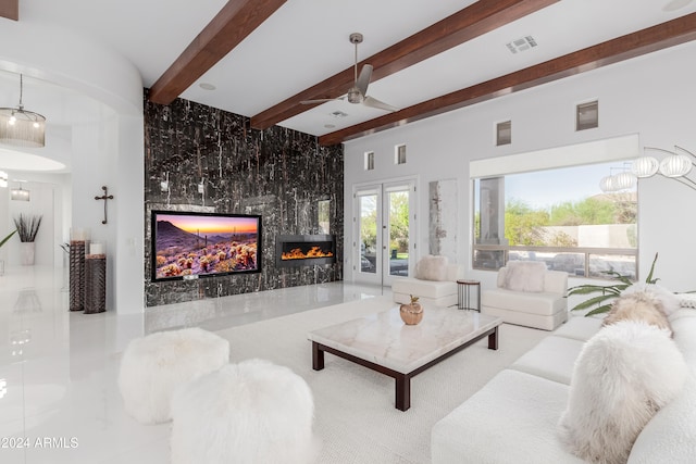 tiled living room featuring beamed ceiling, ceiling fan, a fireplace, and french doors