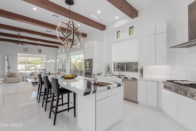 kitchen featuring tasteful backsplash, sink, wall chimney range hood, beam ceiling, and a kitchen island