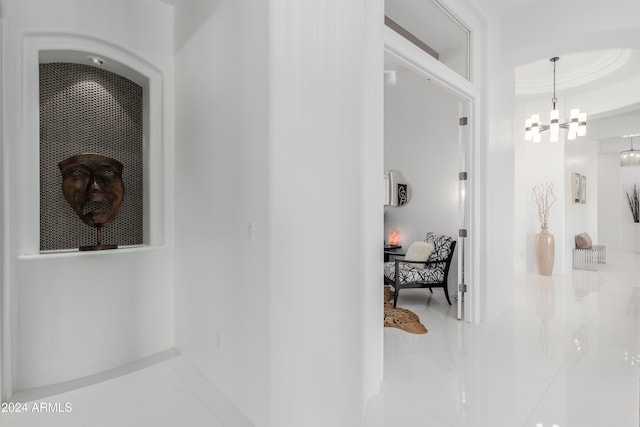 corridor featuring tile patterned floors and a chandelier