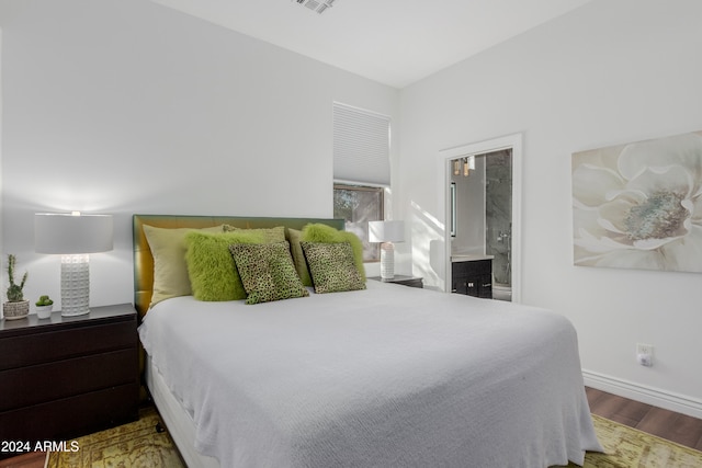 bedroom featuring hardwood / wood-style floors and ensuite bathroom