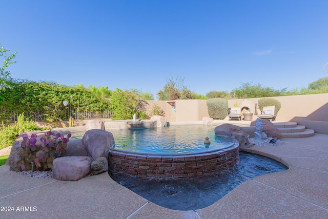 view of swimming pool featuring pool water feature and a patio area