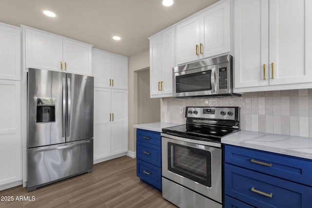 4913 E Acoma Dr, Scottsdale, AZ 85254 - kitchen featuring appliances with stainless steel finishes, blue cabinets, white cabinetry, wood finished floors, and recessed lighting
