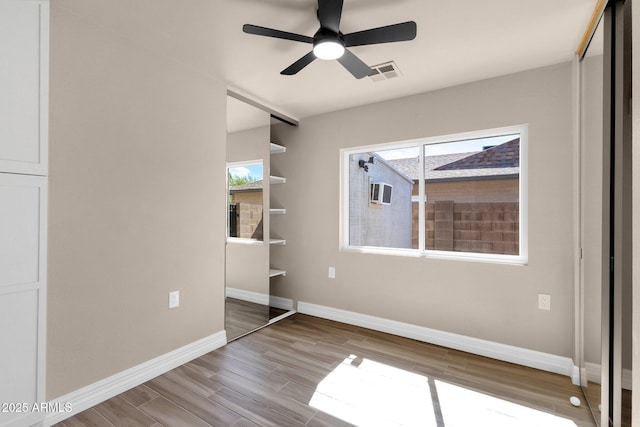 4913 E Acoma Dr, Scottsdale, AZ 85254 - unfurnished bedroom with wood finished floors, baseboards, and multiple windows