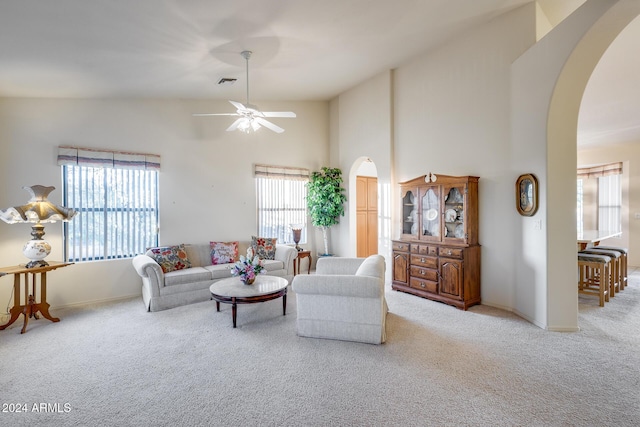 carpeted living room featuring high vaulted ceiling and ceiling fan