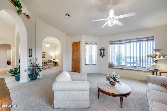 living room with ceiling fan, lofted ceiling, and light carpet